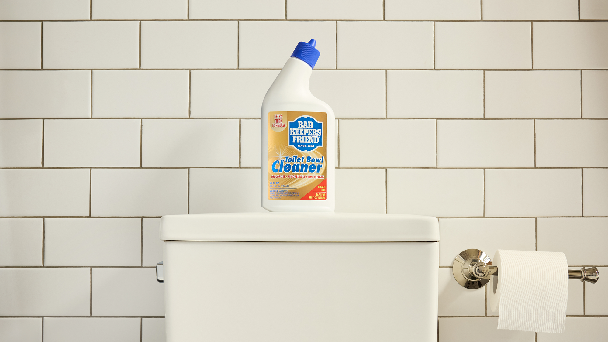Bottle of Clorox cleaner on a toilet tank against a tiled bathroom wall.