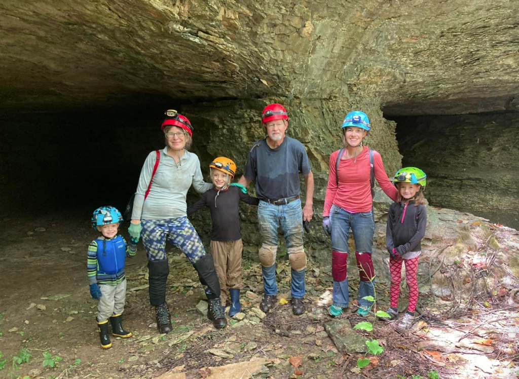 Family standing in front of cave going caving